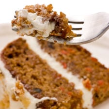 slice of paleo carrot cake with forkful of frosted cake