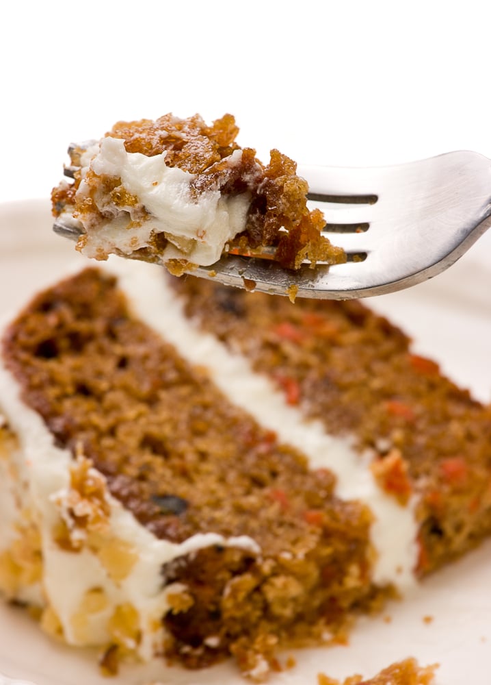 slice of paleo carrot cake with forkful of frosted cake