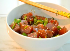 ahi tuna poke in white bowl with chopsticks on side