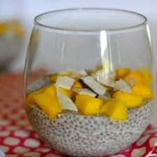 glass full of chia pudding topped with mango and dried coconut