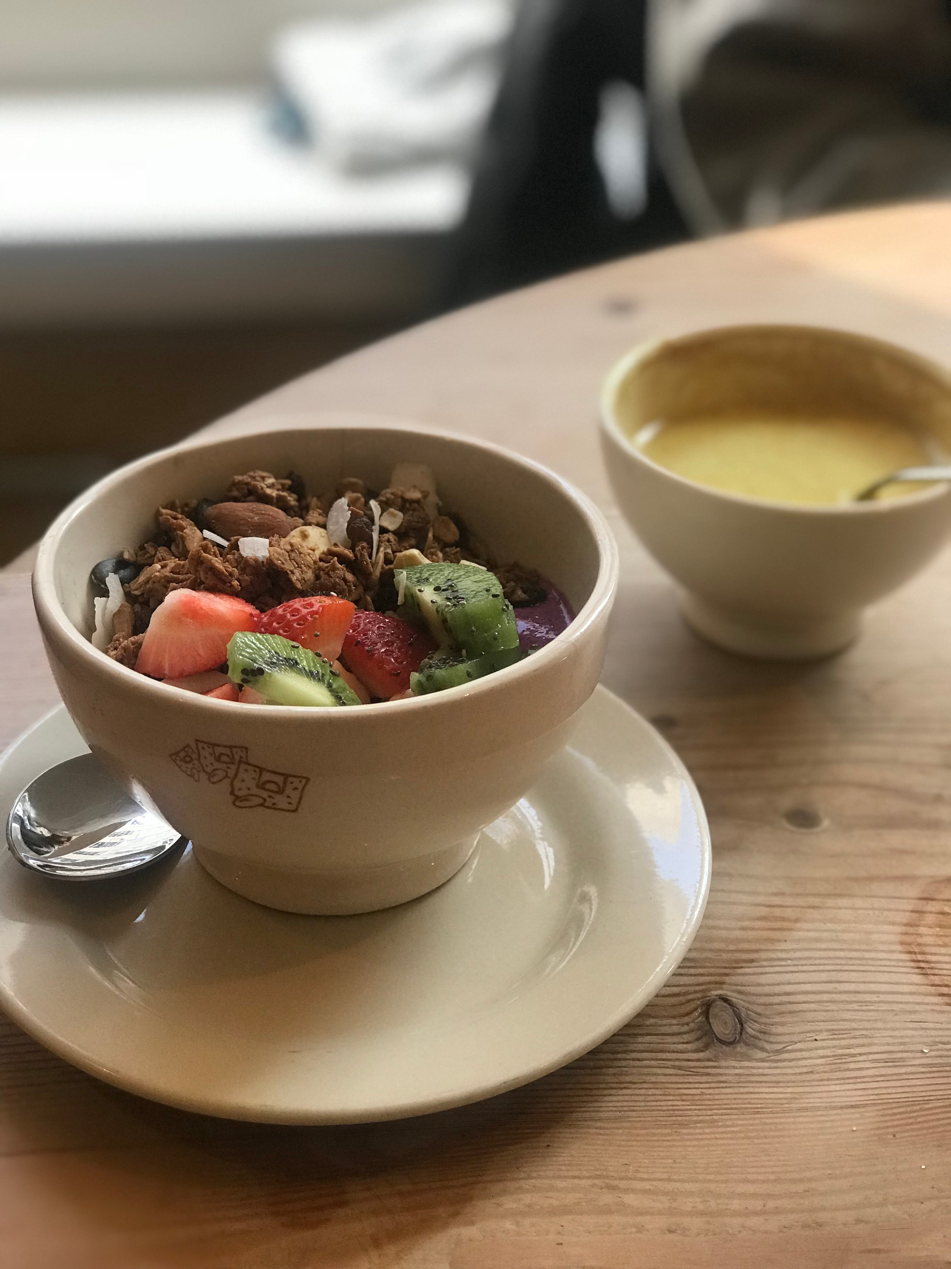 acai bowl with turmeric latte in background