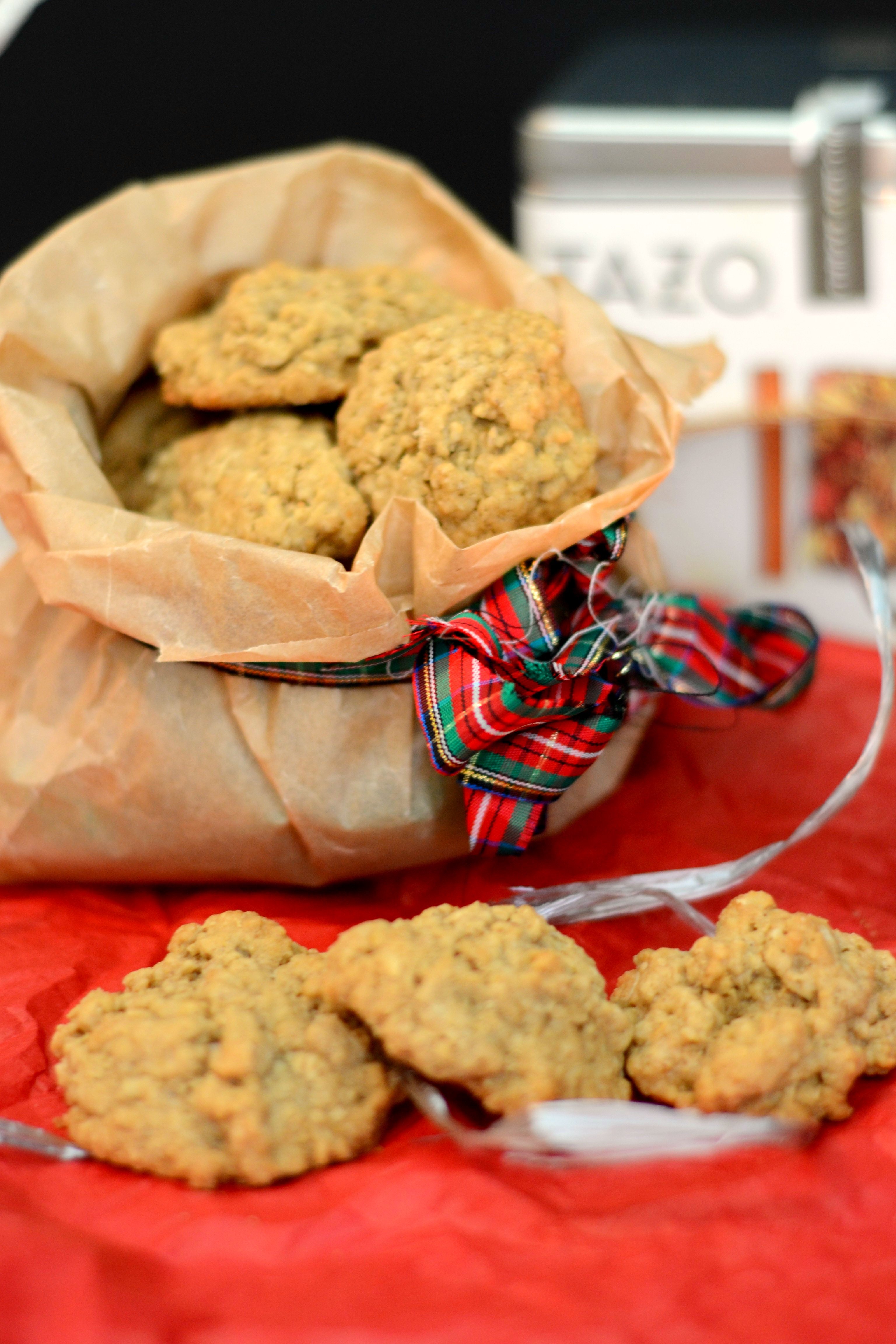 brown paper bag with mini oatmeal cookies pouring out of it surrounded by Christmas decorations