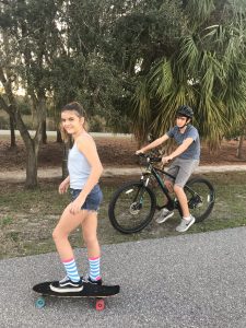 Teen skateboarding and biking