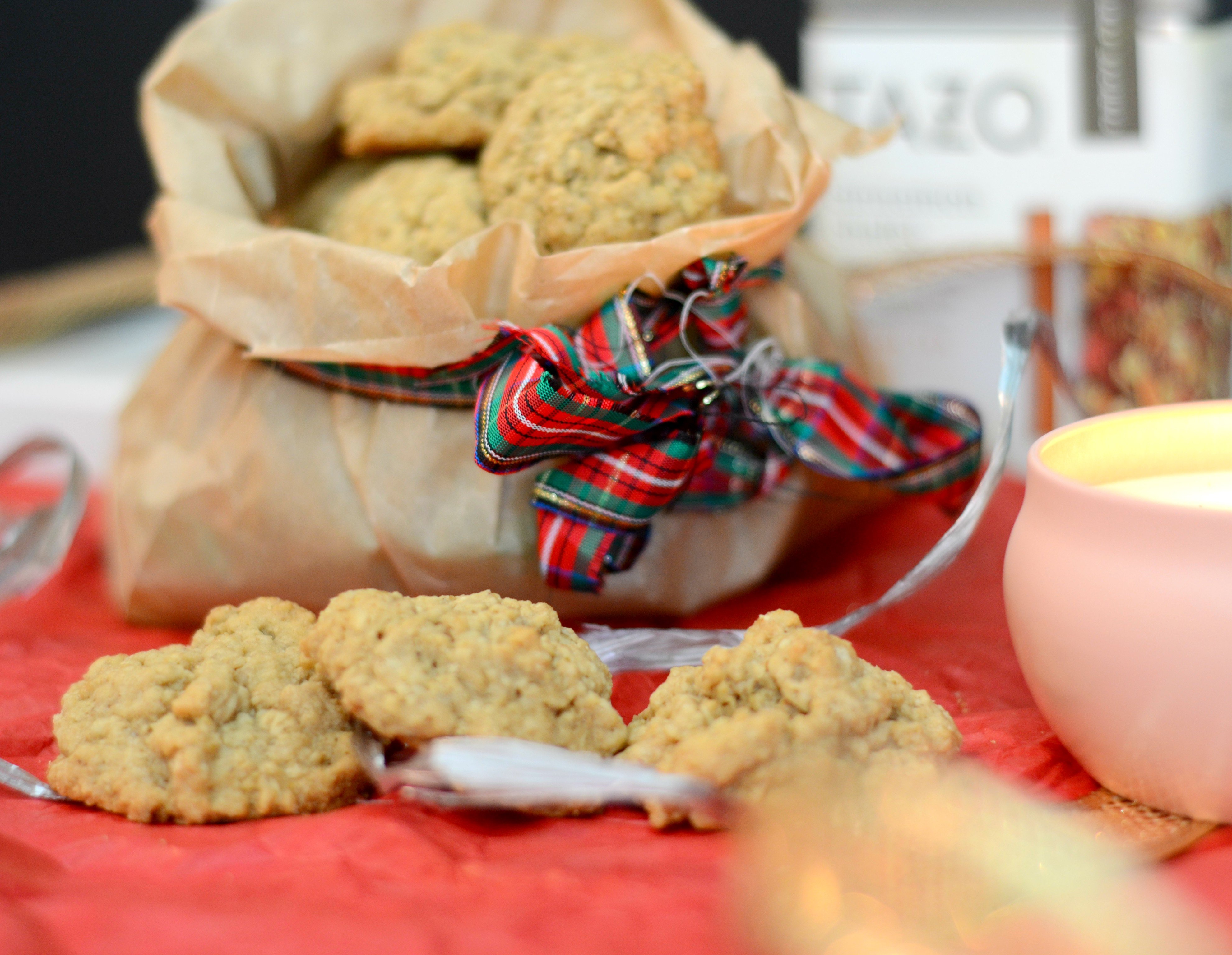 brown paper bag with mini oatmeal cookies pouring out of it surrounded by Christmas decorations