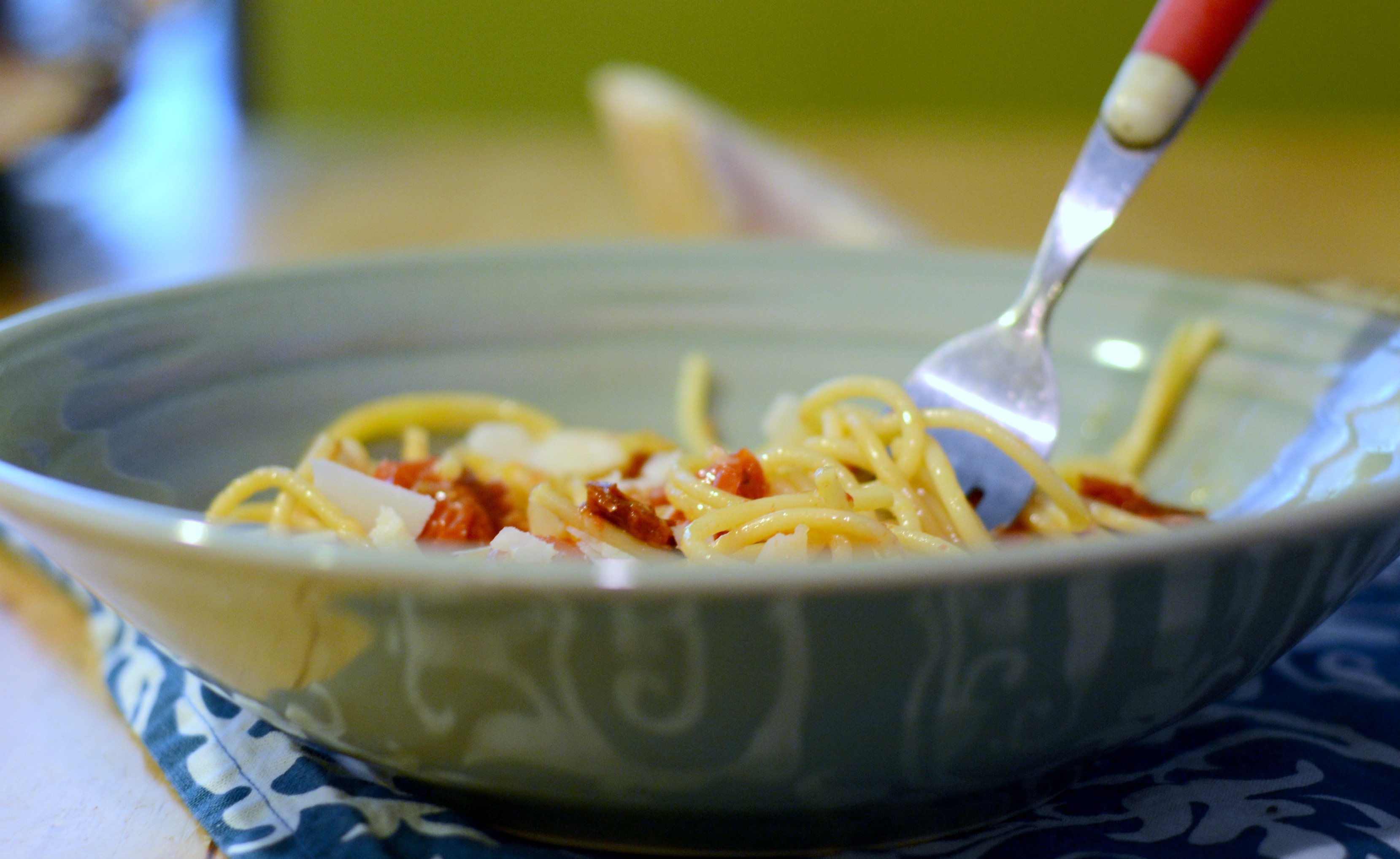 side view of a bowl of pasta with the fork in it