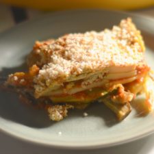 vegan gluten free lasagna on a plate with sunshine coming in from a nearby window