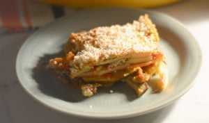 vegan gluten free lasagna on a plate with sunshine coming in from a nearby window