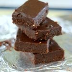 Stack of four raw, vegan brownies with a tinfoil background