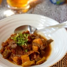 Bowl of Sweet Potato Chili with beer in the backgroun