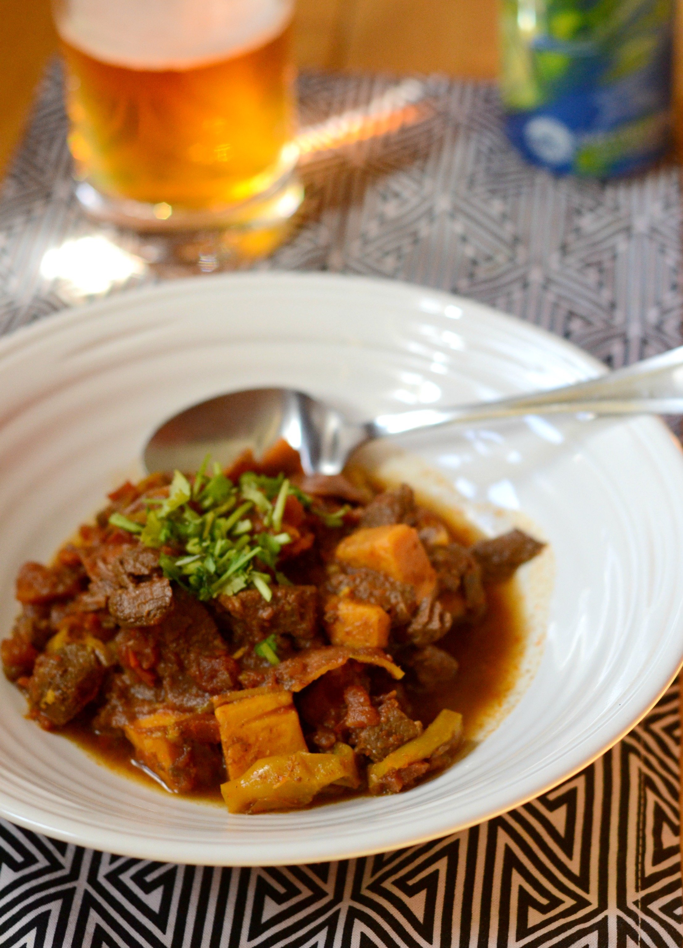 Bowl of Sweet Potato Chili with beer in the backgroun