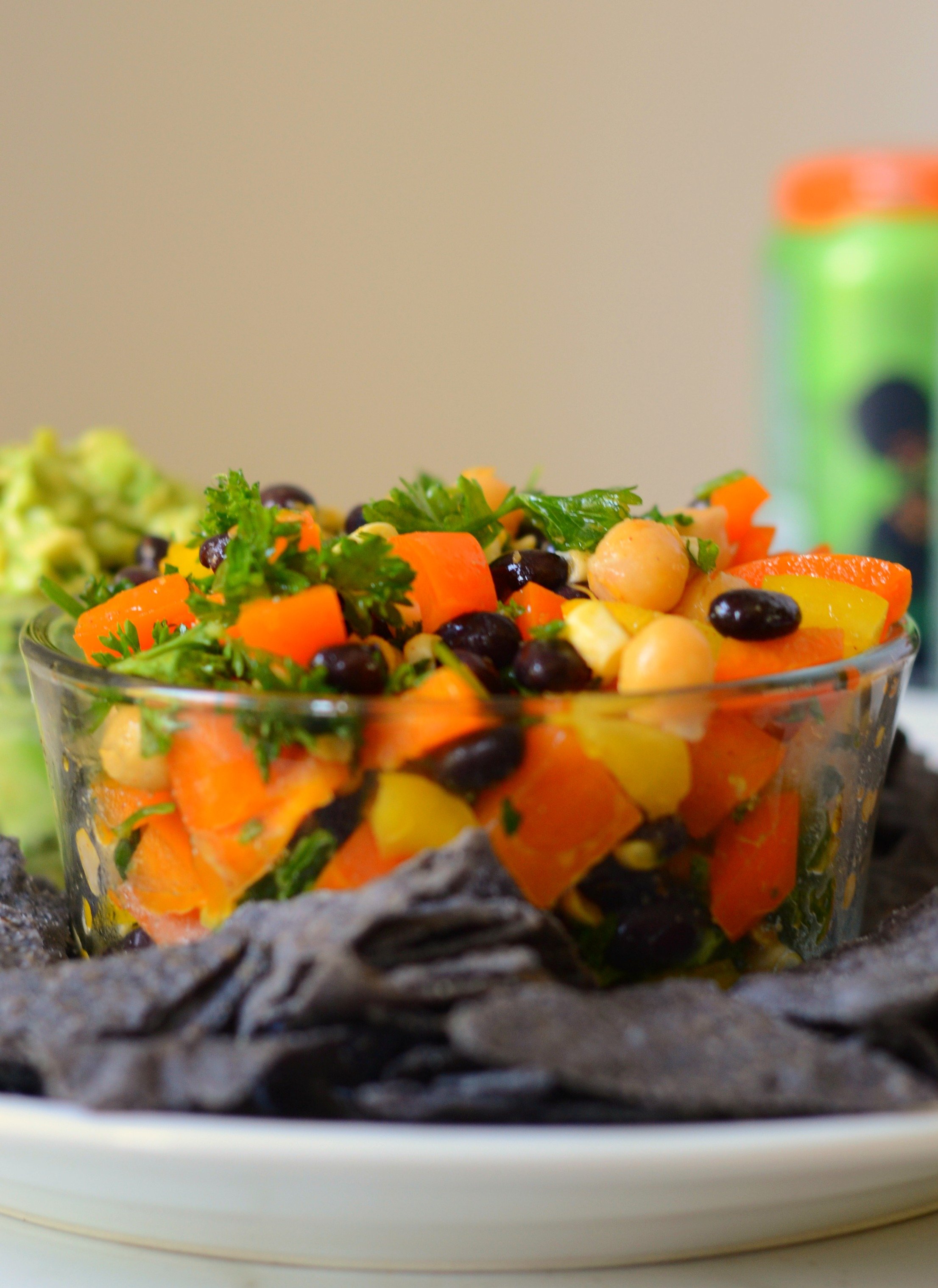 close up bowl of Puerto Rican bean salad with blue tortilla chips