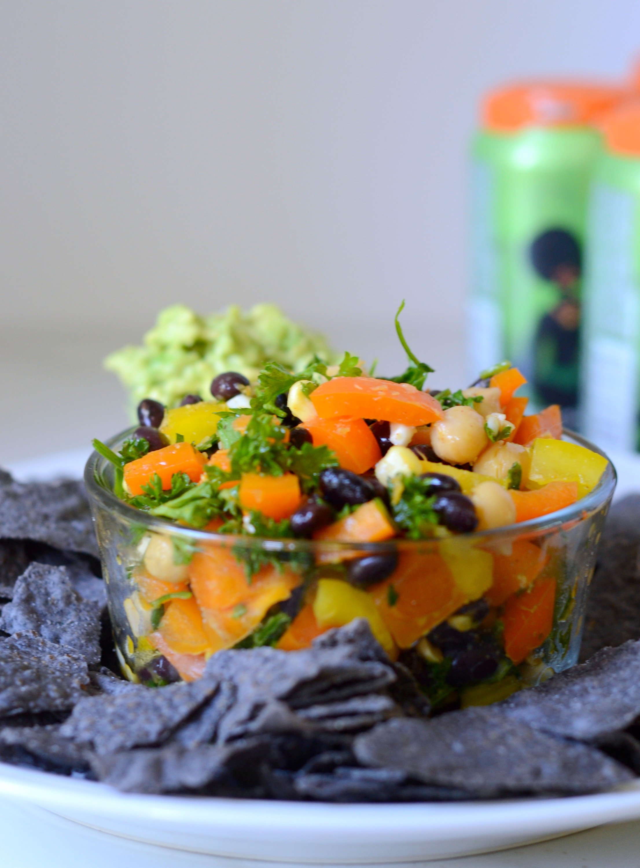 Bowl of Puerto Rican Bean Salad with blue tortilla chips and beer