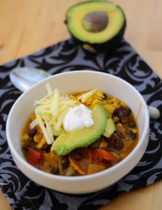 Bowl of Vegetarian Tortilla Soup topped with avocados, cheese and sour cream