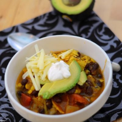 Bowl of Vegetarian Tortilla Soup topped with avocados, cheese and sour cream