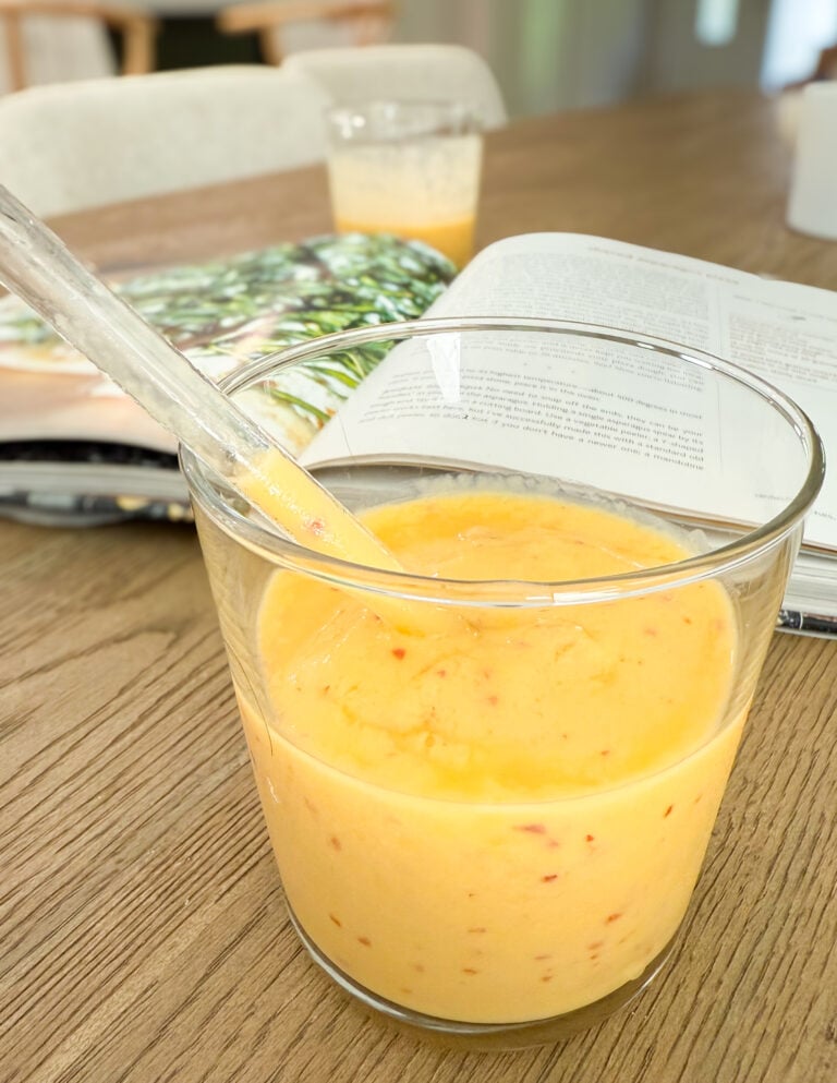 Mango Peach Smoothie in the foreground with a cookbook in the background.